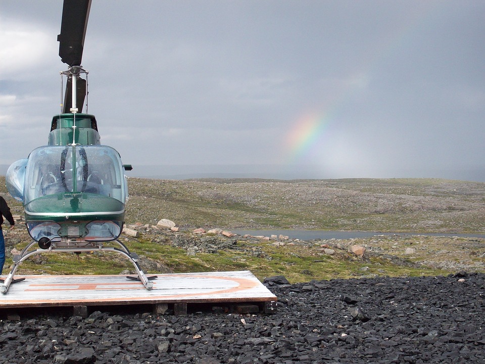 Nunavut — Helicopter on tundra helipad with rainbow